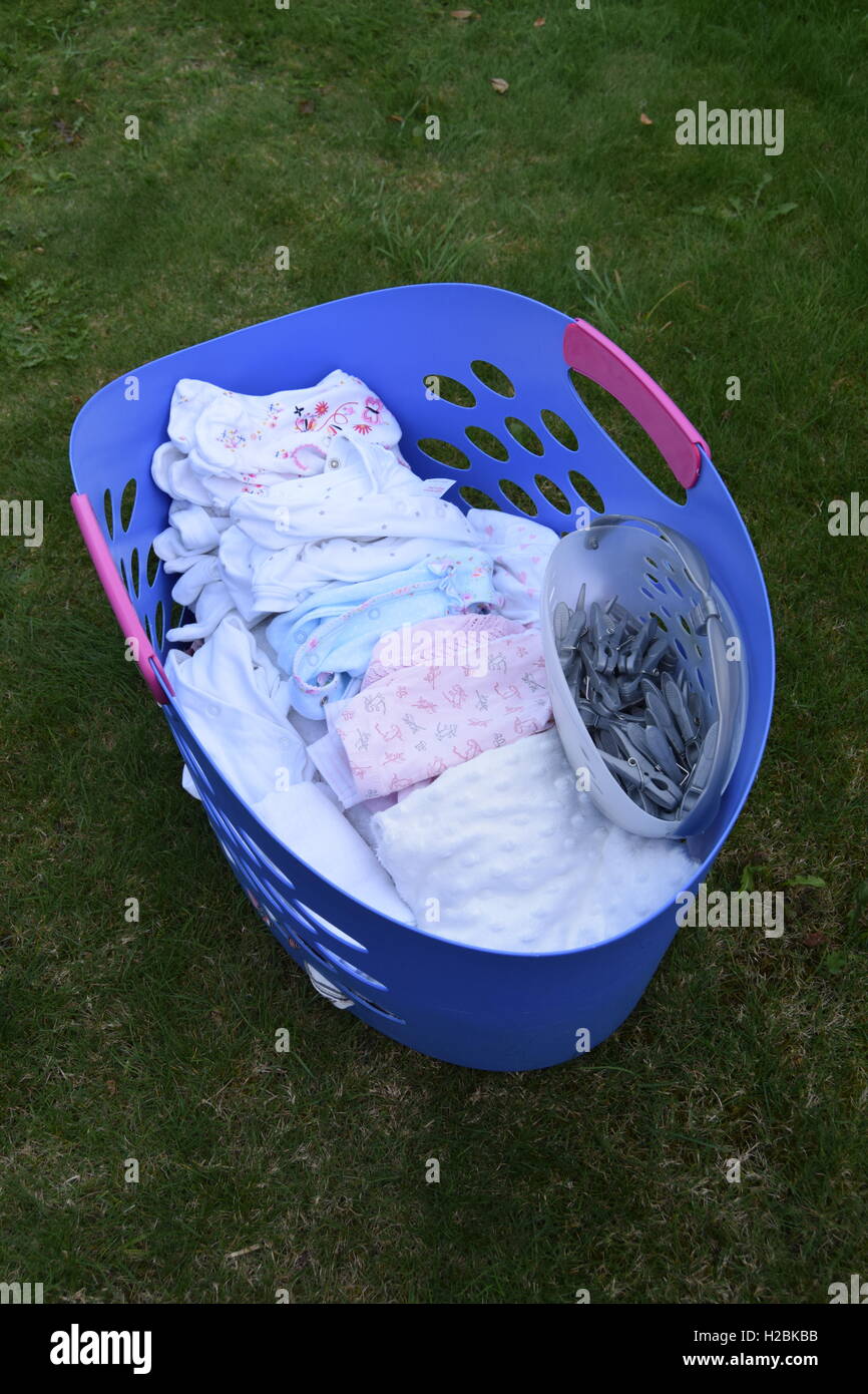 Laundry basket full of baby clothes Stock Photo Alamy