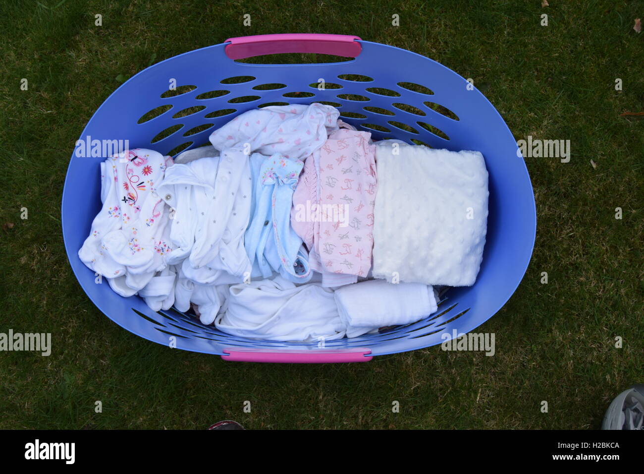 Laundry basket full of baby clothes Stock Photo Alamy