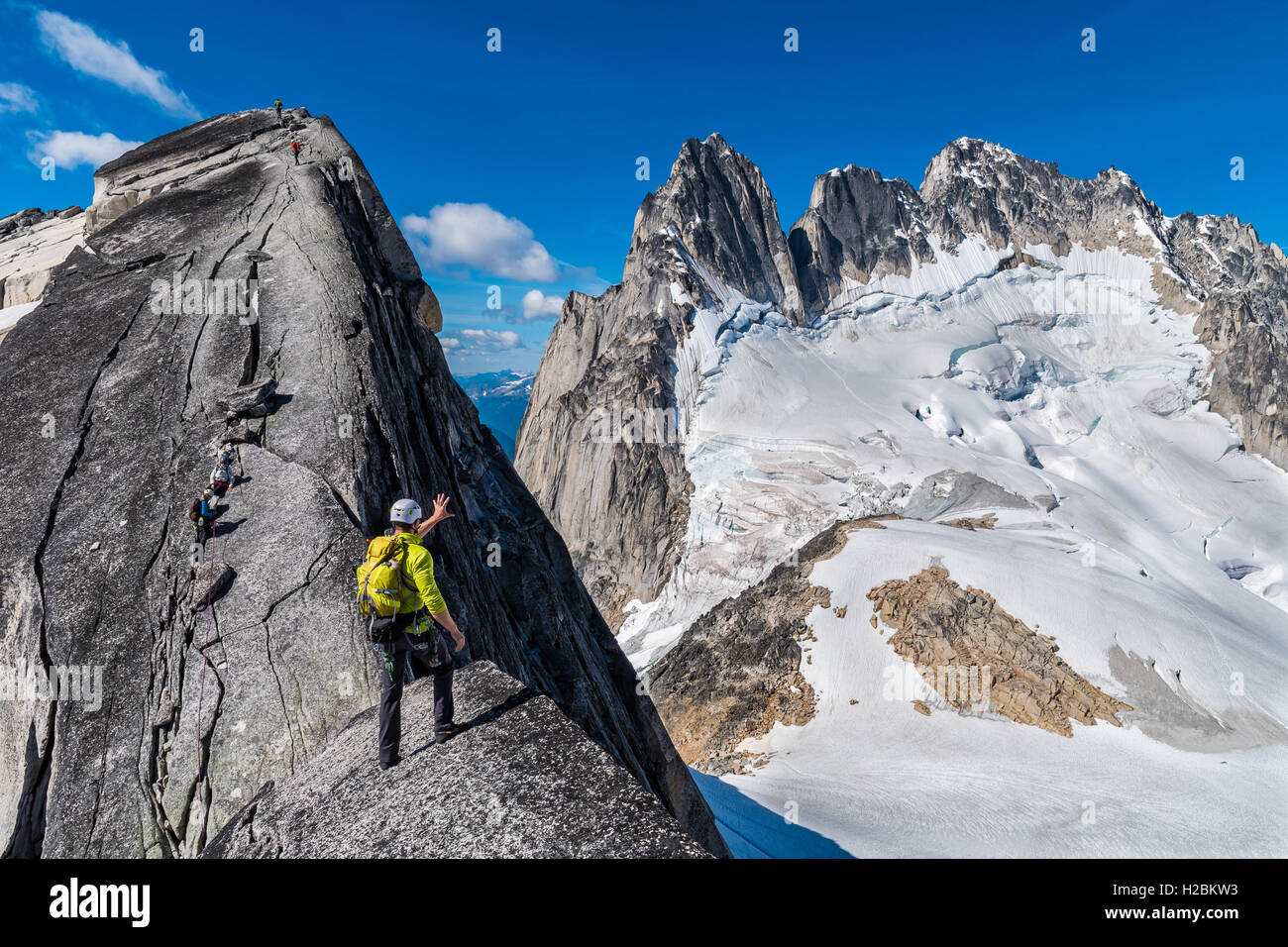 Elijah Weber sizes up the Howser Spire on the summit of Pigeon Spire in the Bugaboo Provincial Park Stock Photo