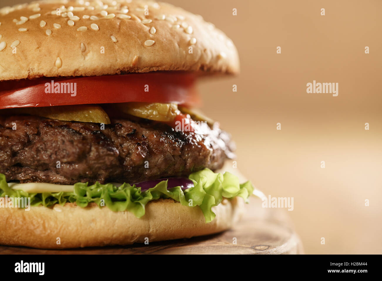 closeup fresh homemade burger with marble beef, cheese and vegetables on olive board Stock Photo