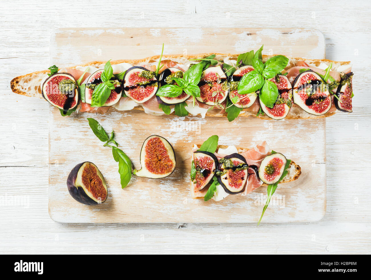 Long baguette sandwich with prosciutto, mozzarella, arugula, figs and
