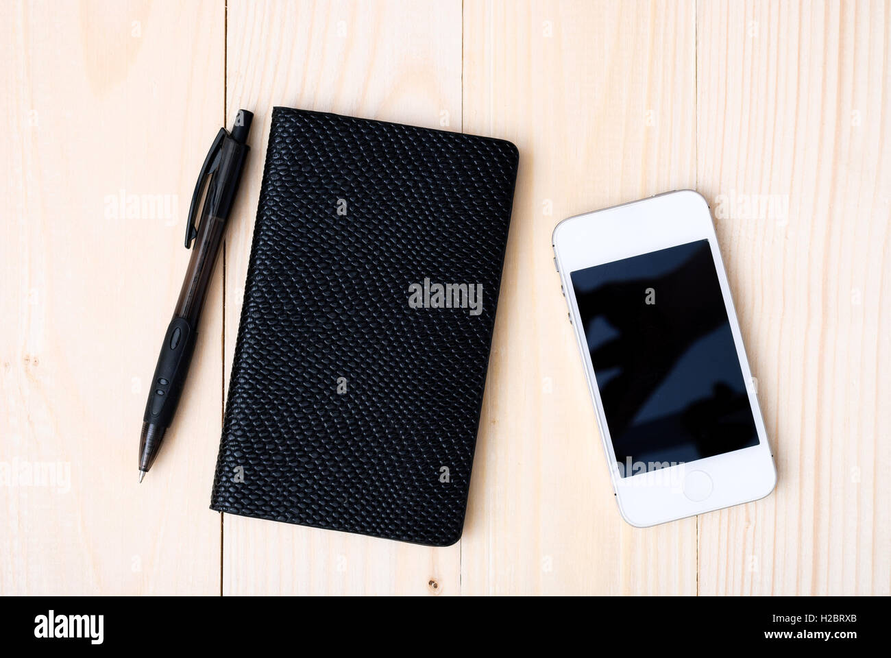 Small notepad with pen and smartphone Stock Photo - Alamy