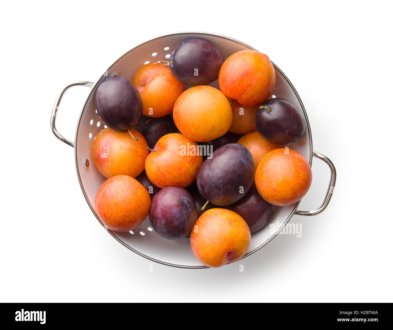 Yellow and purple plums in colander. Top view Stock Photo - Alamy