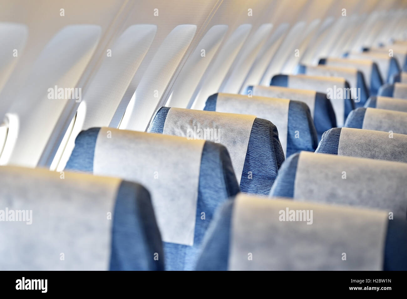 Blue airplane empty seats with new head rest covers Stock Photo