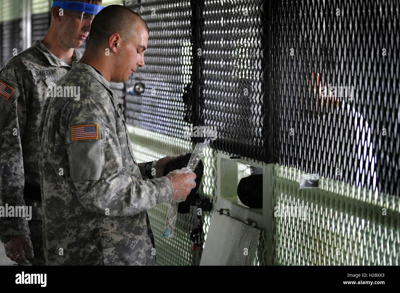 A U.S. Army soldier hands an inmate prayer beads at the Joint Task Guantanamos Camp IV July 7, 2010 in Guantanamo Bay, Cuba. Stock Photo