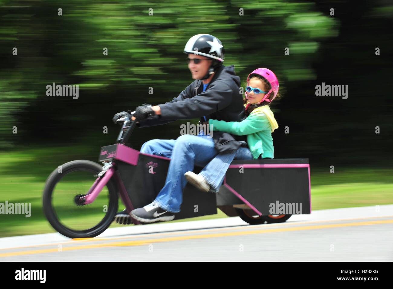 A father and daughter pair ride their homemade soapbox derby race car down a hill on Douglas Boulevard during the American Red Cross Derby Day May 1, 2010 at the Kadena Air Base in Okinawa City, Okinawa, Japan. Stock Photo