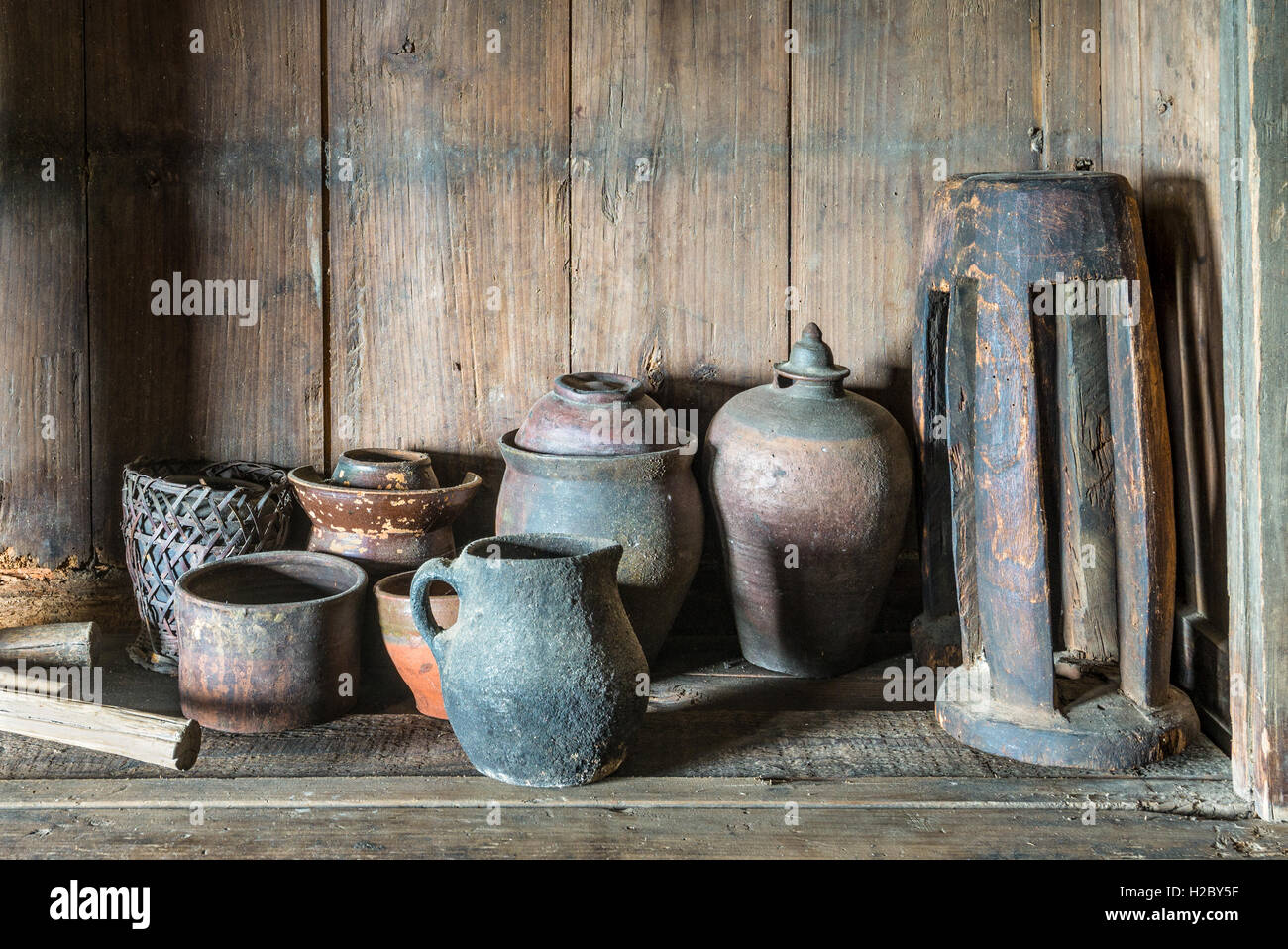 Traditional Chinese old pottery and wooden household items on background of wooden planks Stock Photo