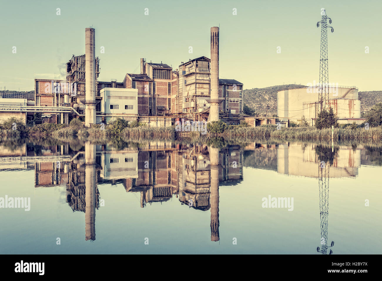 Old factory that is reflected in the river.Photo in vintage styles Stock Photo
