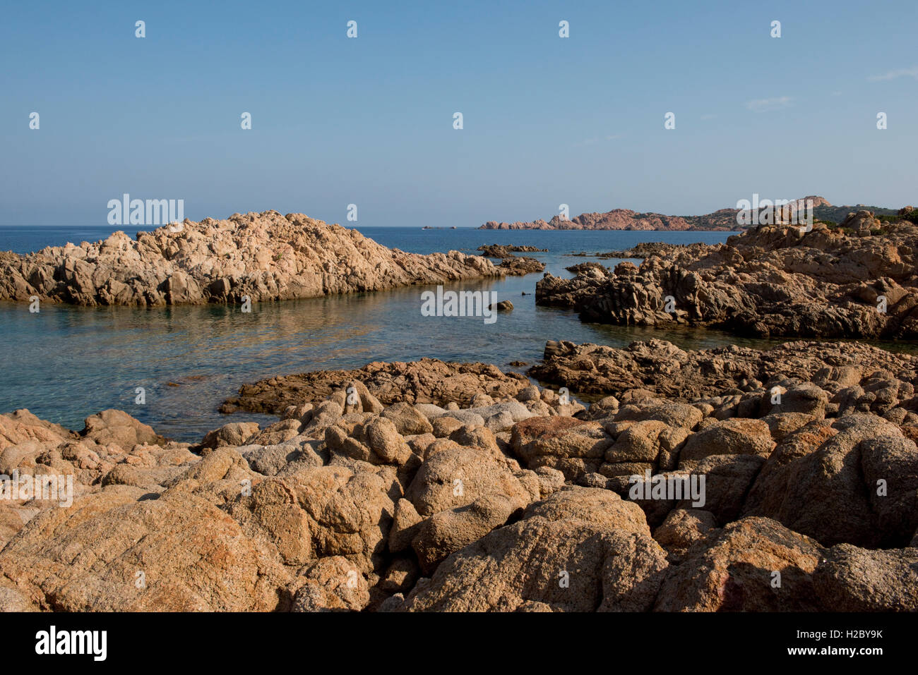 Red granite rugged coastline and blue sea of the Isola Rossa in western Sardinia, September Stock Photo