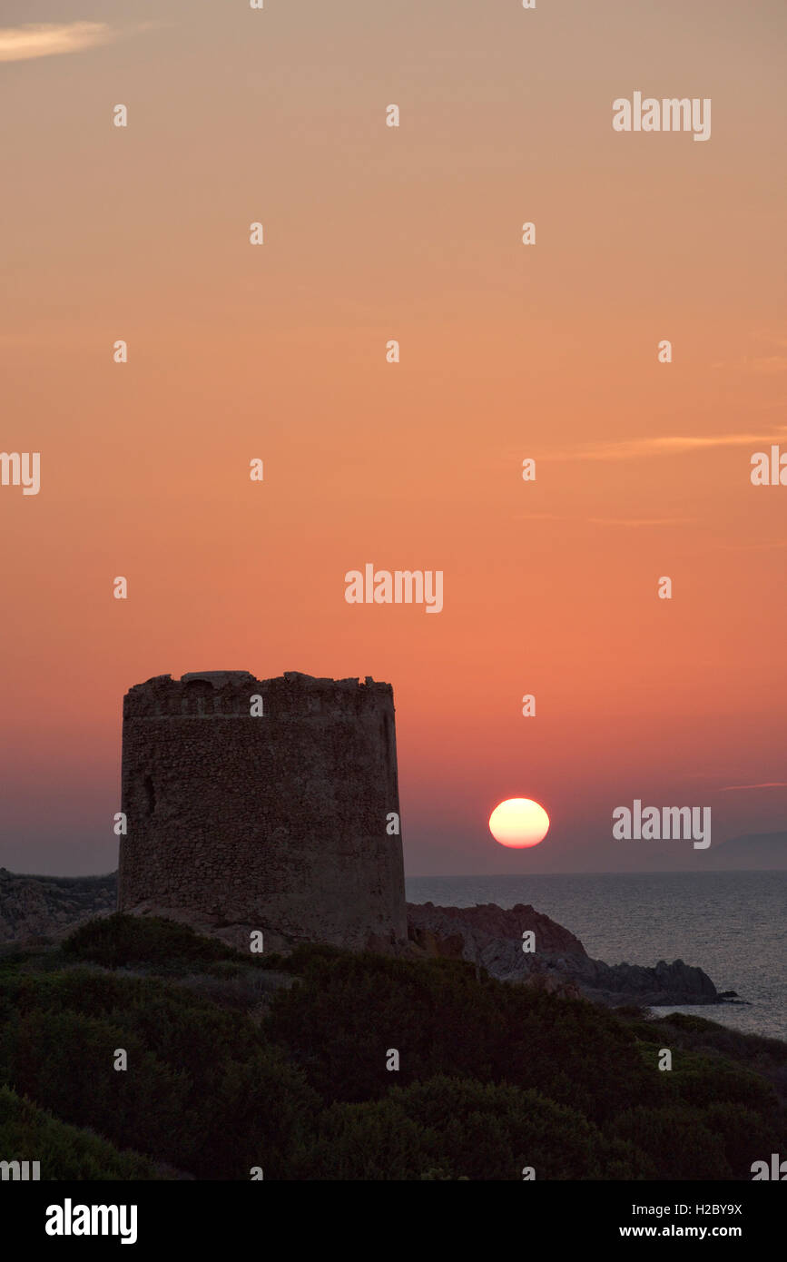 La Torre Spagnola, the Spanish Tower, in Isola Rossa Sardinia with the sun setting behind, September Stock Photo