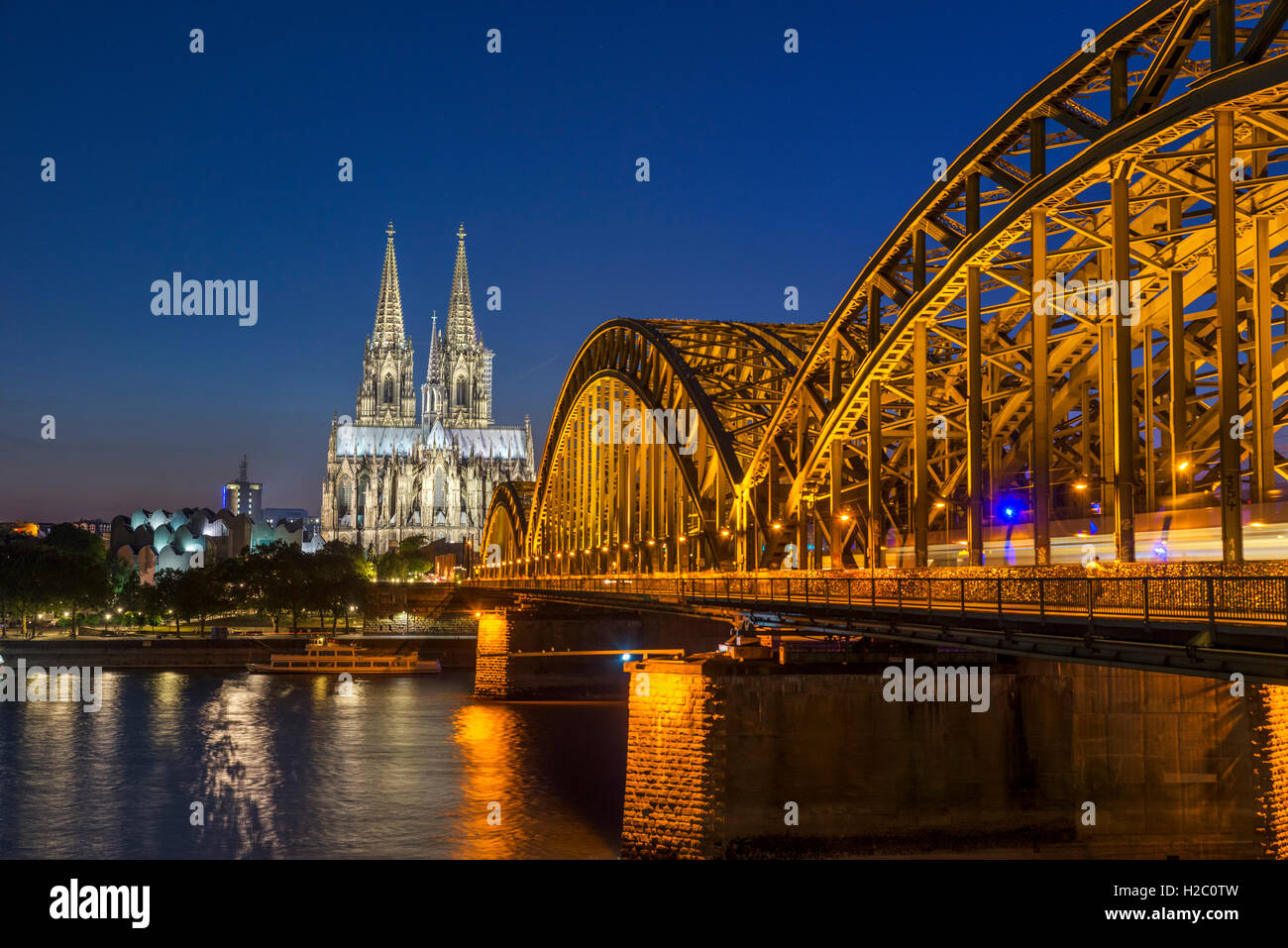 River Rhine at night, looking towards Cologne Cathedral with the Hohenzollern Bridge in the foreground, Cologne, Germany Stock Photo