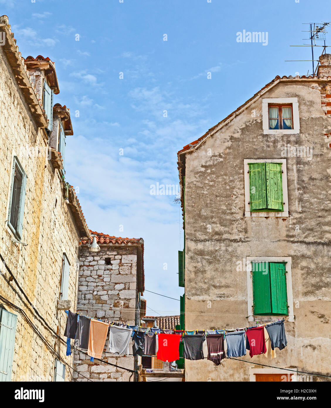 Split, Croatia, old town houses, window shutters, washing hanging on a line. Blue sky Stock Photo