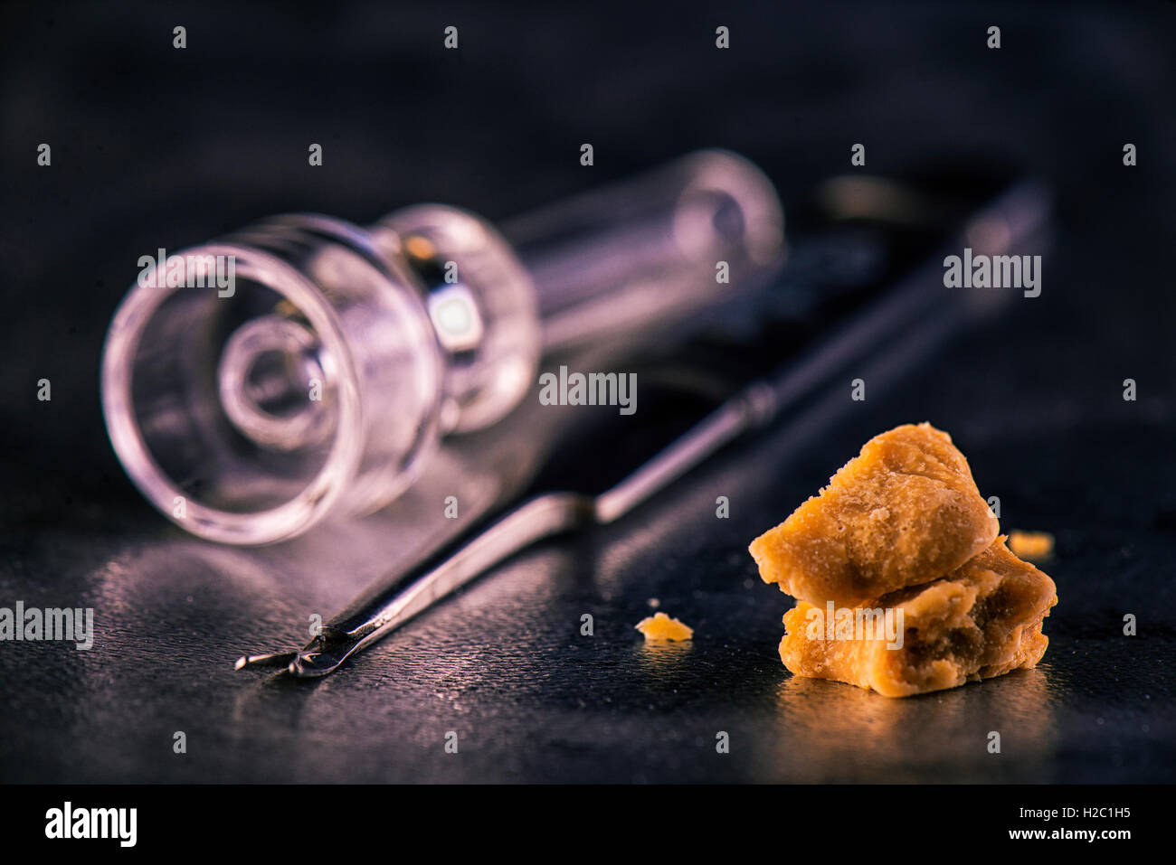 Marijuana extraction concentrate aka wax crumble on dark background with tools Stock Photo