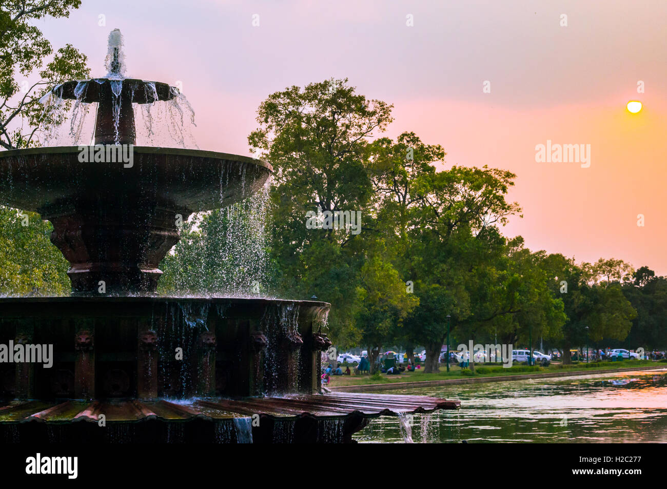 India gate fountain at dusk with a beautiful sky and green trees in the background Stock Photo