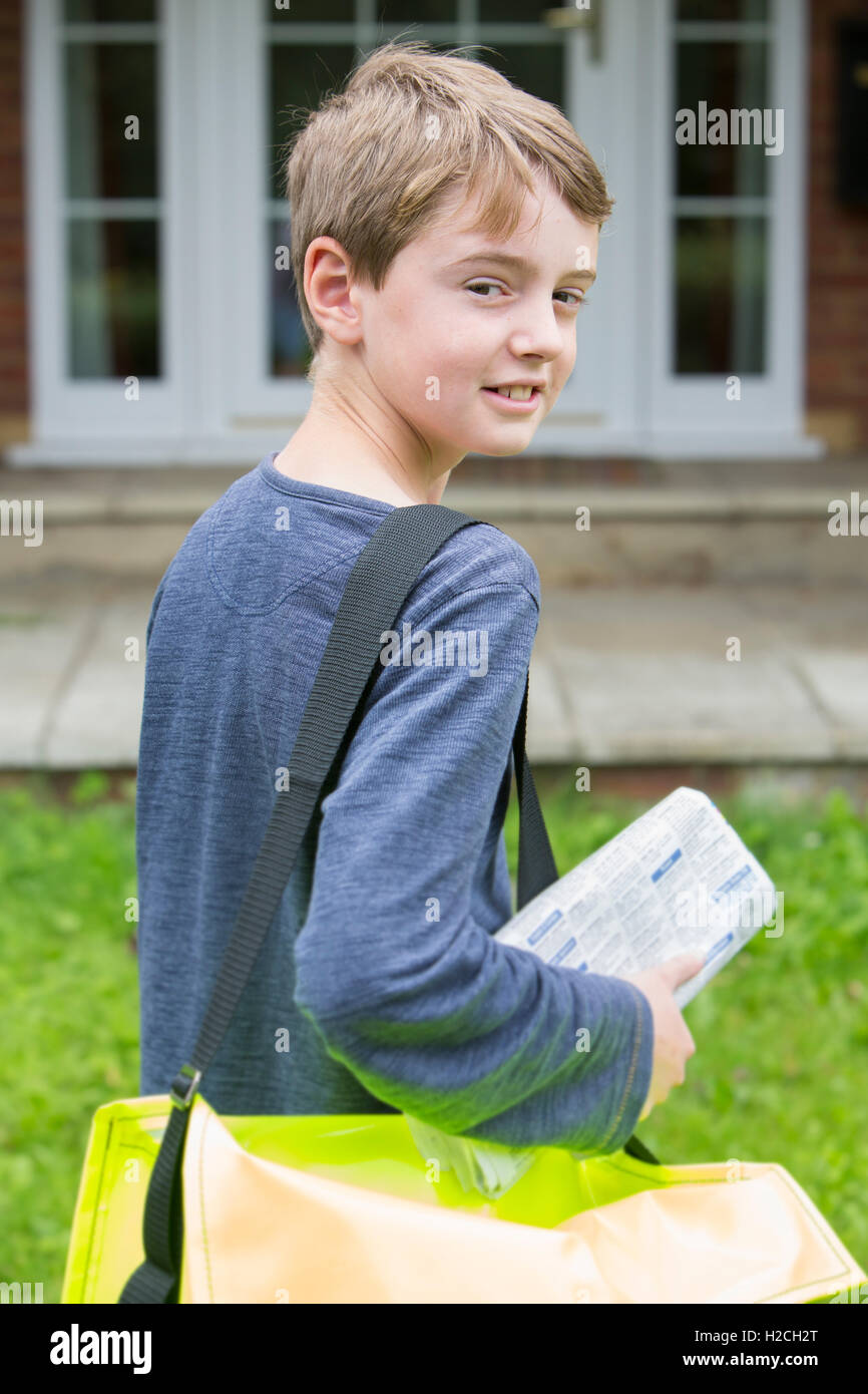 Portrait Of Teenage Boy Delivering Newspaper To House Stock Photo