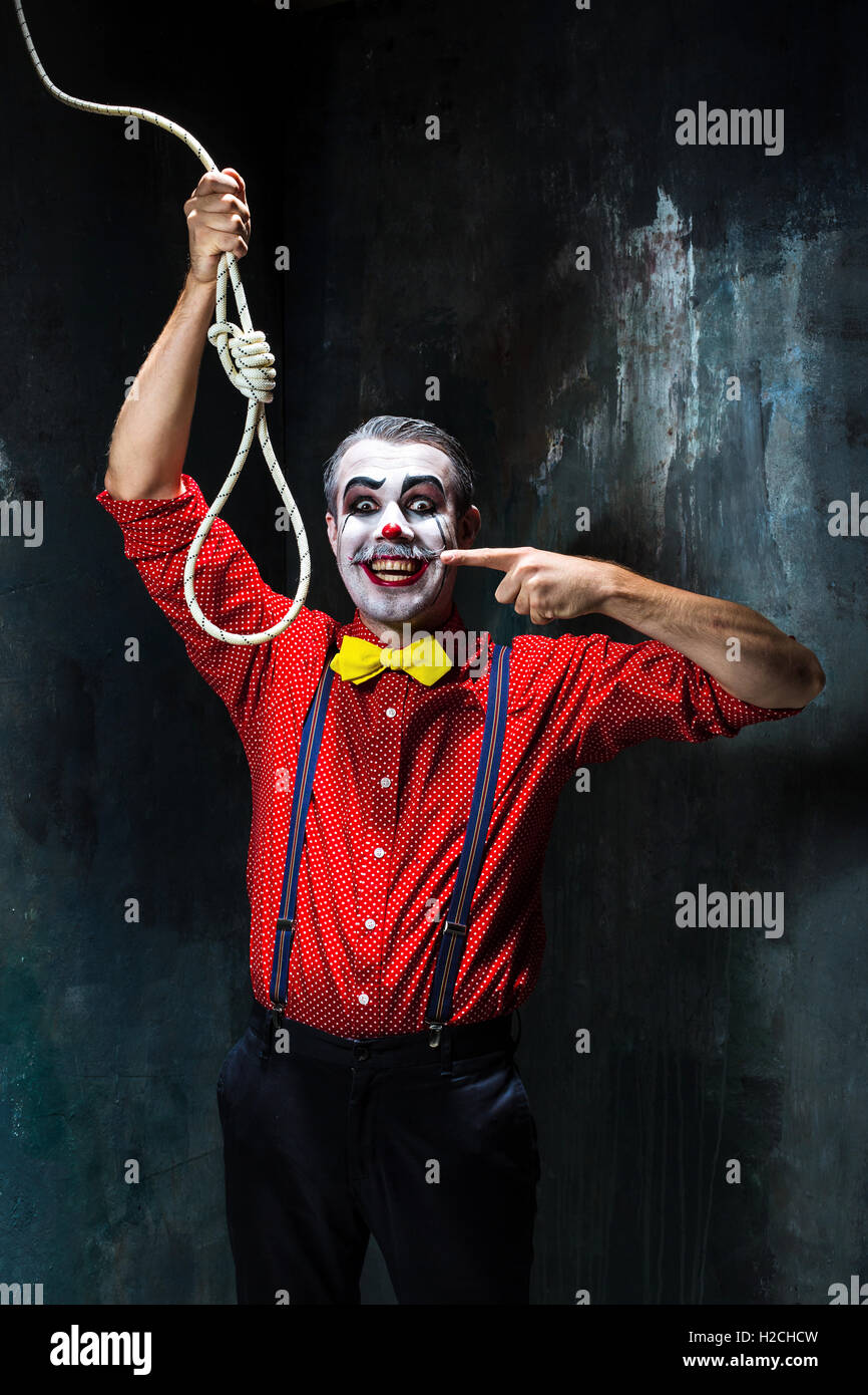 The scary clown and rope for hanging on dack background. Halloween concept Stock Photo