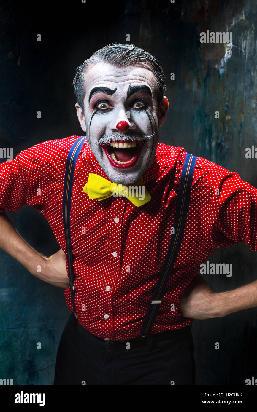 Terrible clown and Halloween theme: Crazy red clown in a shirt with suspenders Stock Photo