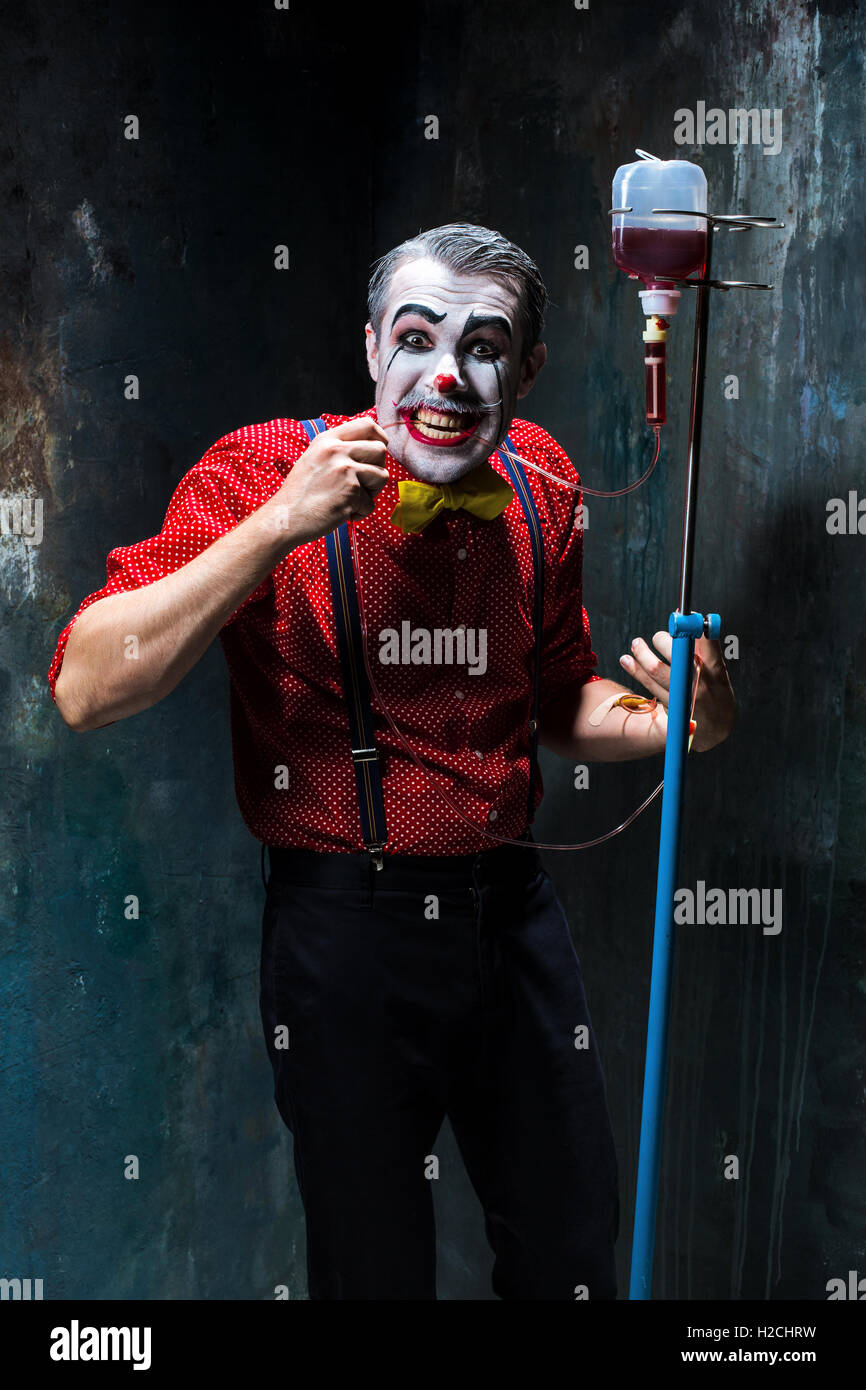 The scary clown and drip with blood on dack background. Halloween concept Stock Photo