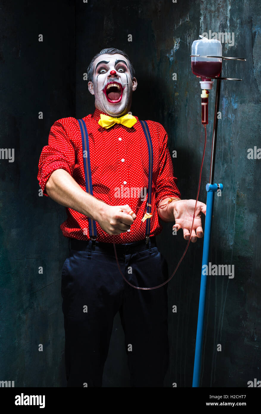 The scary clown and drip with blood on dack background. Halloween concept Stock Photo