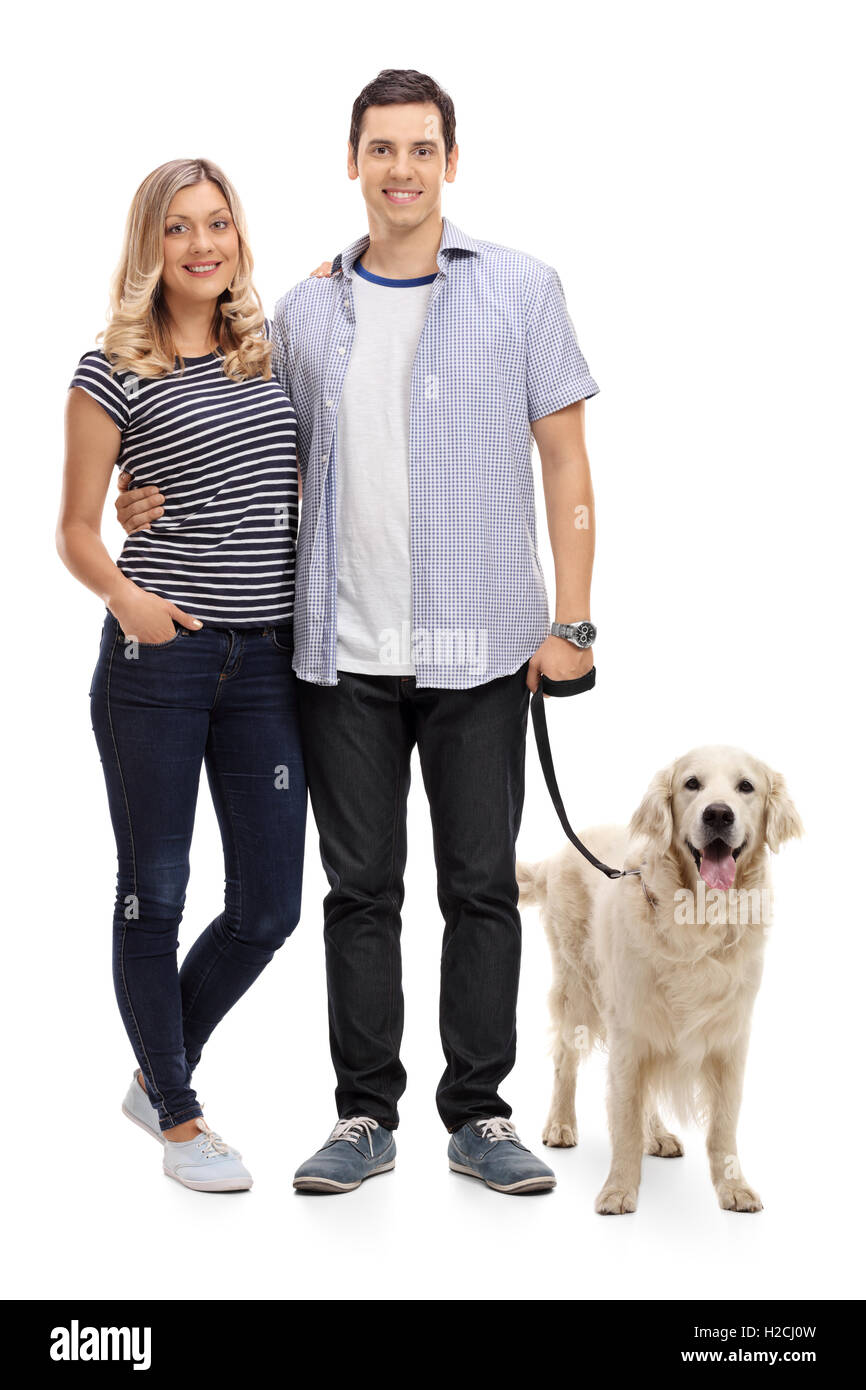 Full length portrait of a young couple posing with their dog isolated ...