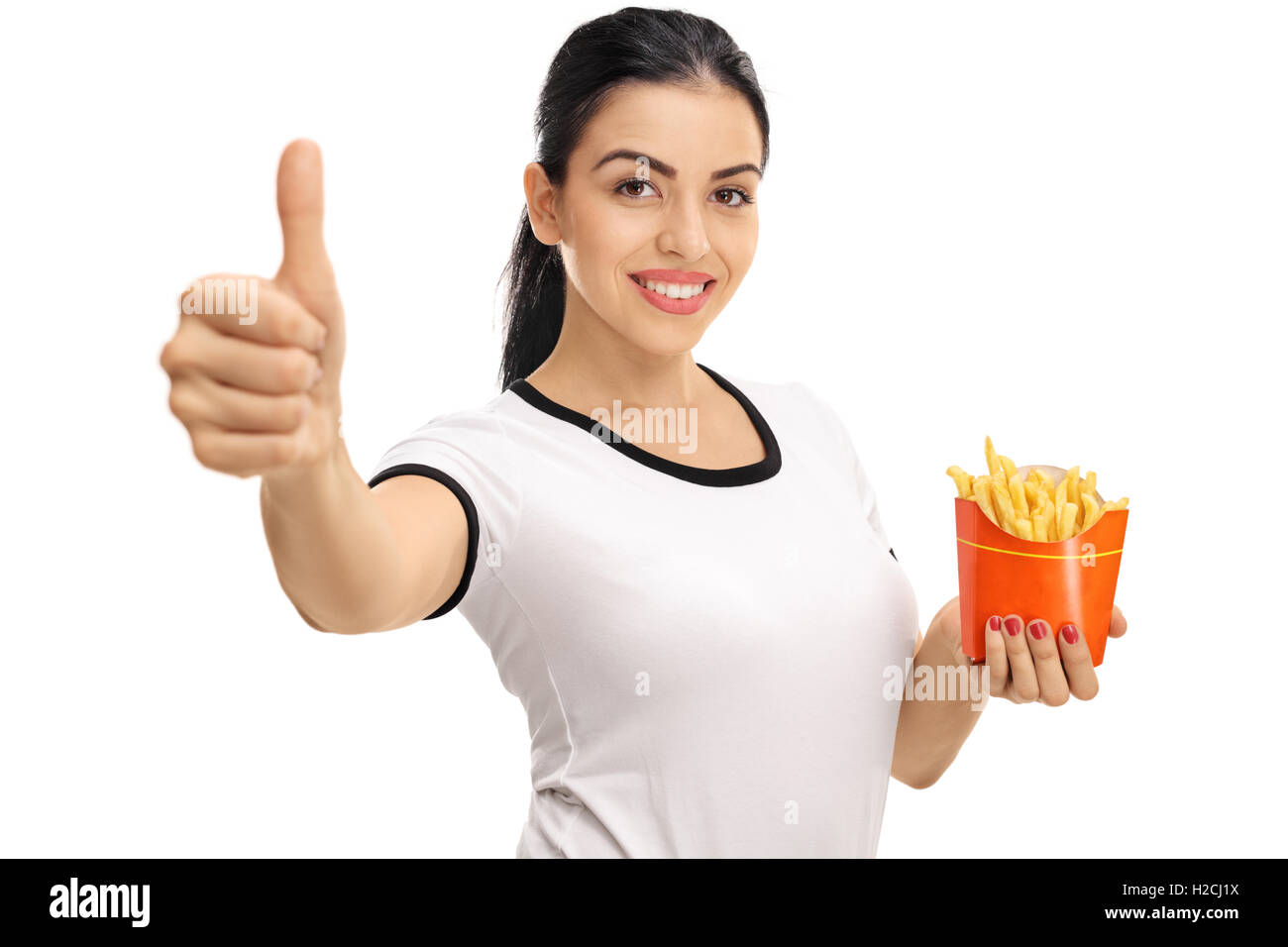 Smiling woman holding a bag of fries and giving a thumb up isolated on white background Stock Photo