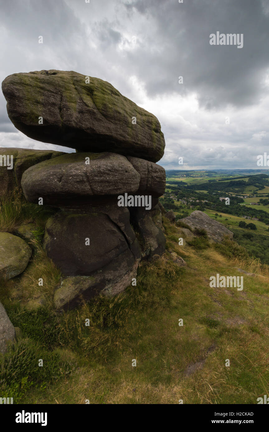 Some large bolders in the foreground on top of a hill near Froggatt Edge in the Peak District, Derbyshire, UK Stock Photo