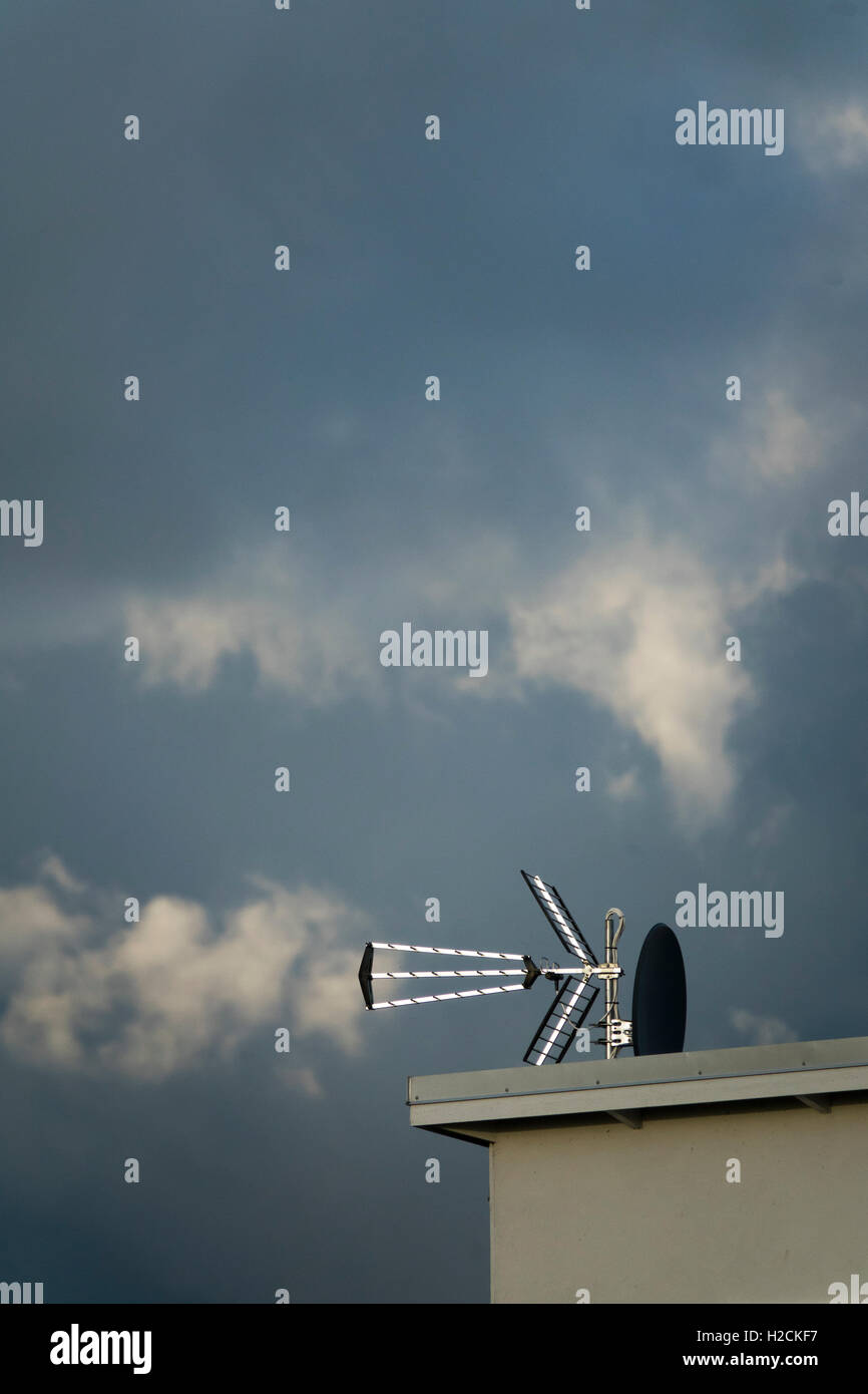 House exterior with antenna on the roof and clouds in the sky with copy space. Stock Photo