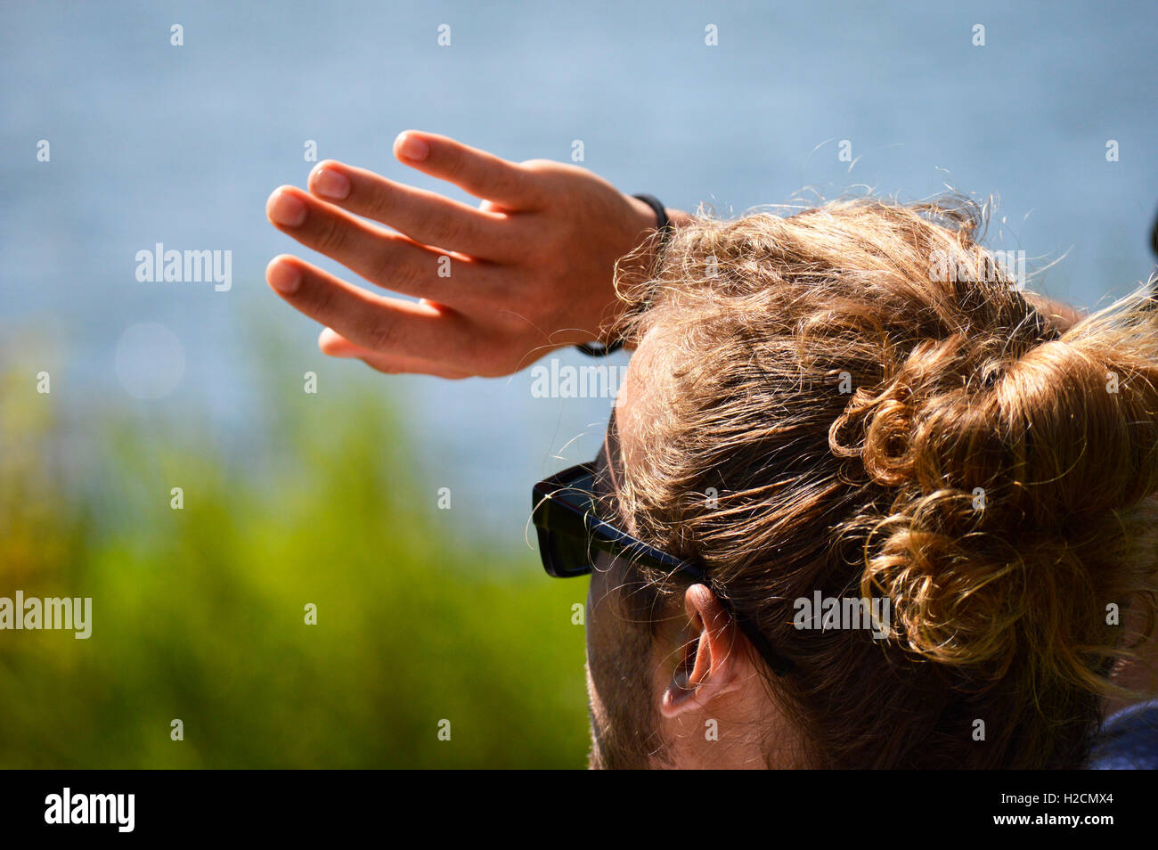 Man blocks the sun from his eyes. Stock Photo