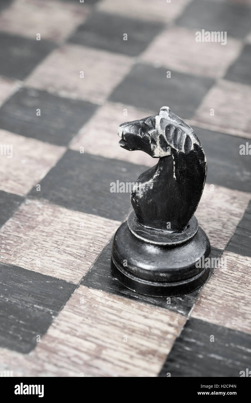 vintage wooden black knight piece on chessboard Stock Photo