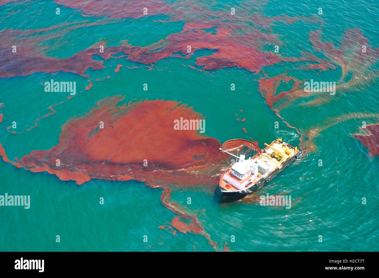 A NOAA skimmer vessel removes oil from the sea surface and attempts to contain some of the oil leaked into the Gulf of Mexico after an offshore explosion on the BP Deepwater Horizon well platform in the Macondo Prospect April 2010 off the coast of Louisiana. Stock Photo