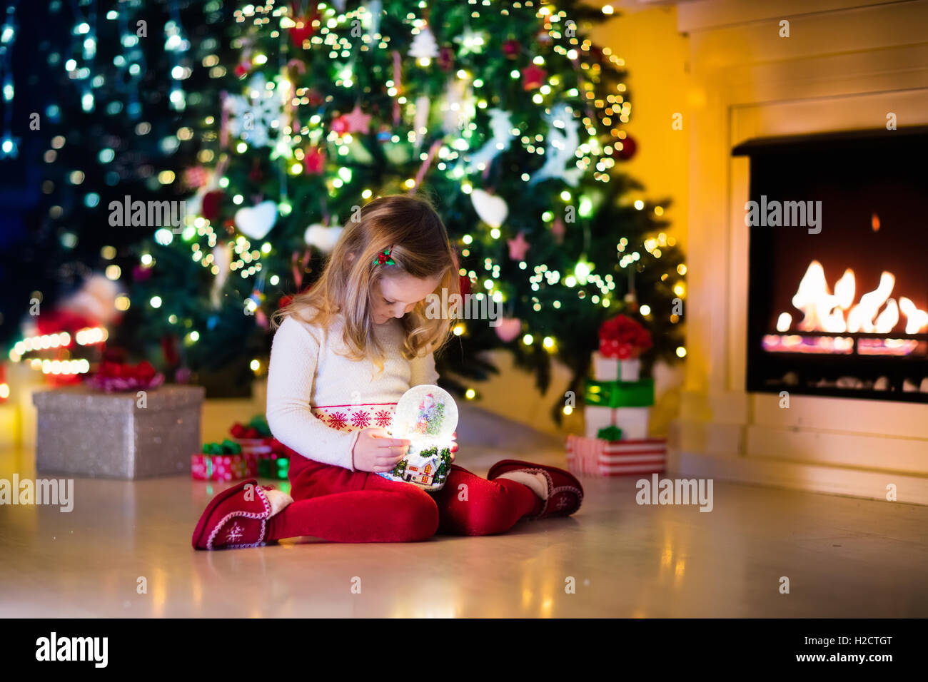 Family On Christmas Eve At Fireplace Little Girl Opening Xmas