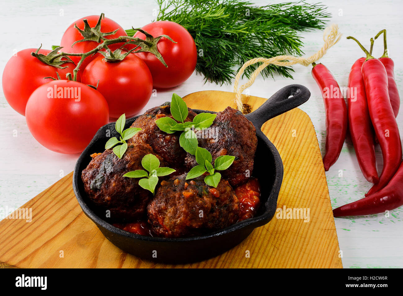 Meatballs with chili pepper and tomato served in cast iron skillet