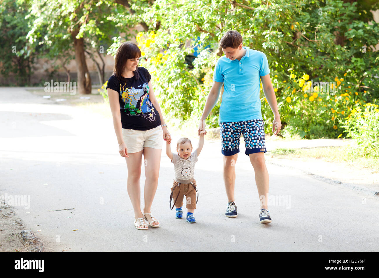 child with mom and dad walking Stock Photo - Alamy