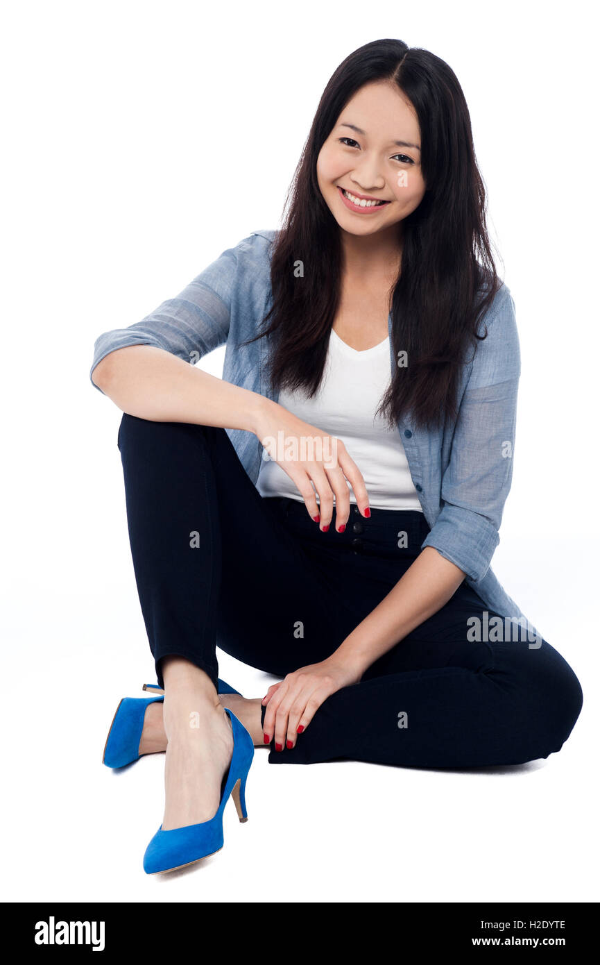 Fashionable smiling girl sitting on the floor Stock Photo - Alamy