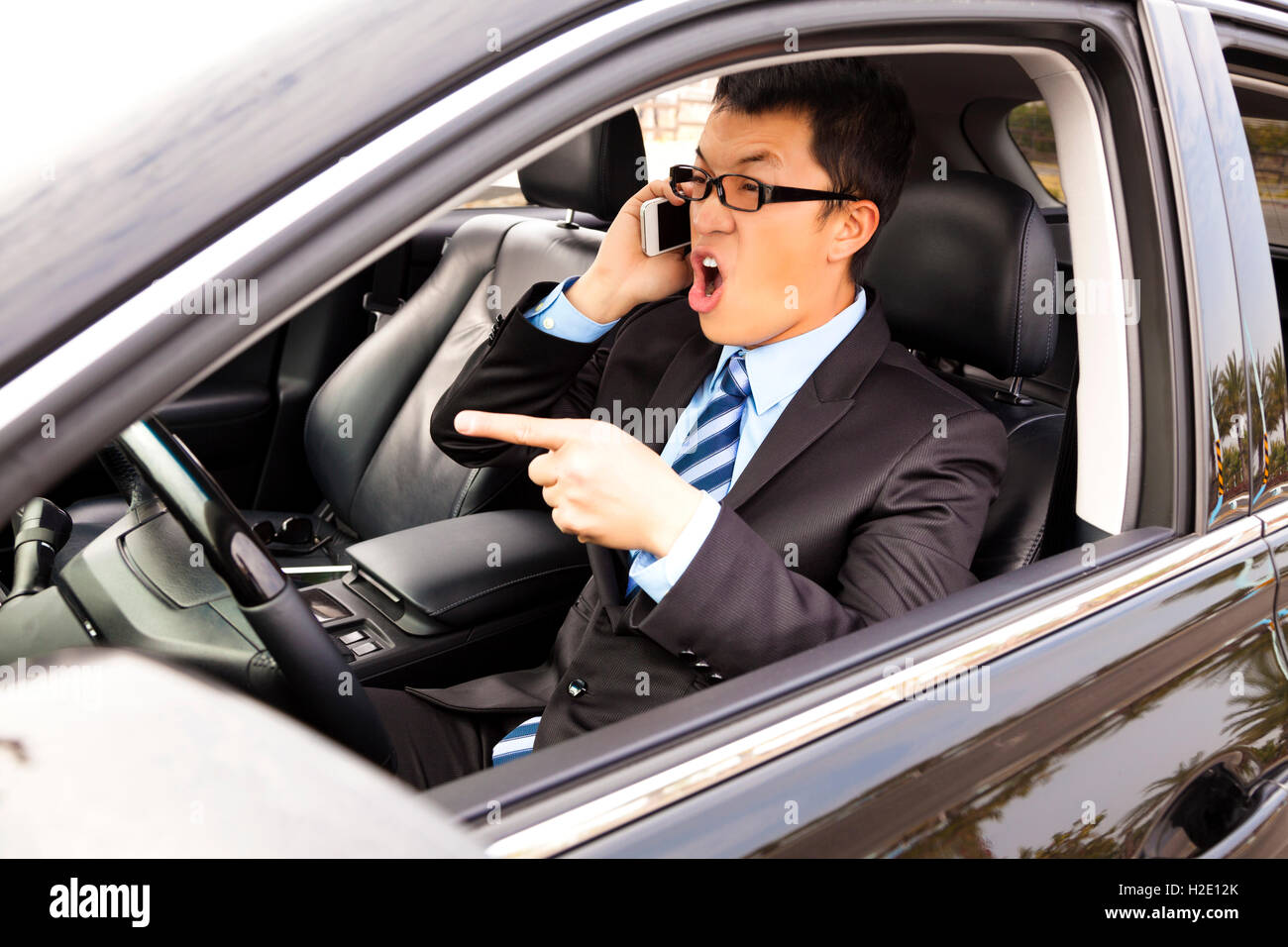 irate businessman talking with cell phone in the car Stock Photo