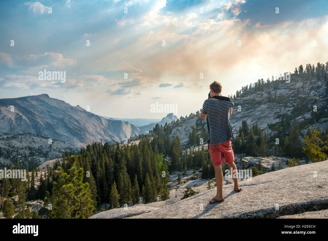 Young man, tourist photographing High Sierra, Olmsted Point, Yosemite National Park, California, USA Stock Photo
