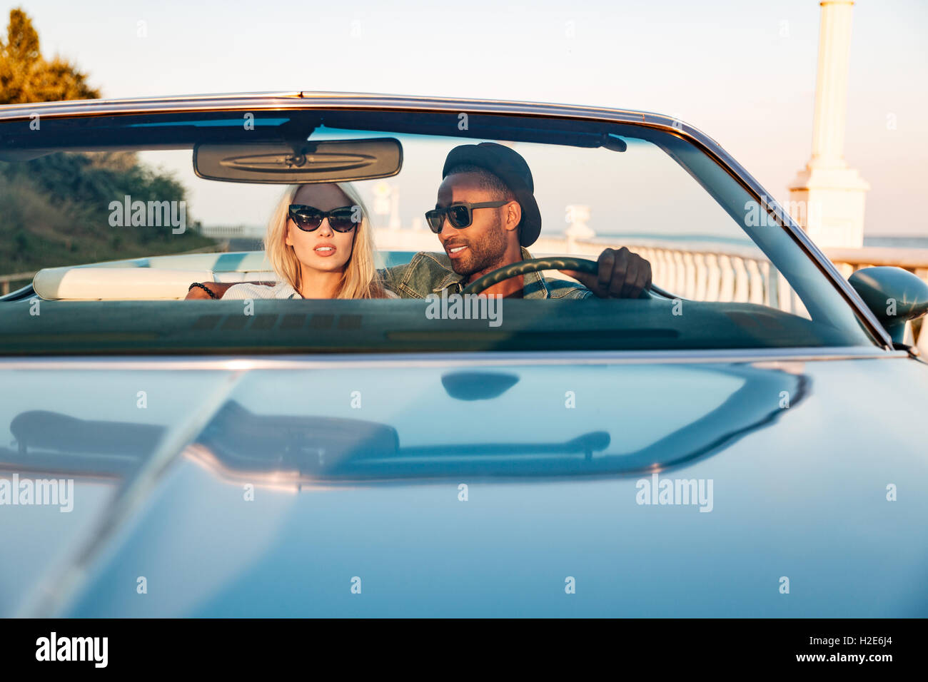 Multiethnic beautiful young couple driving car in summer Stock Photo