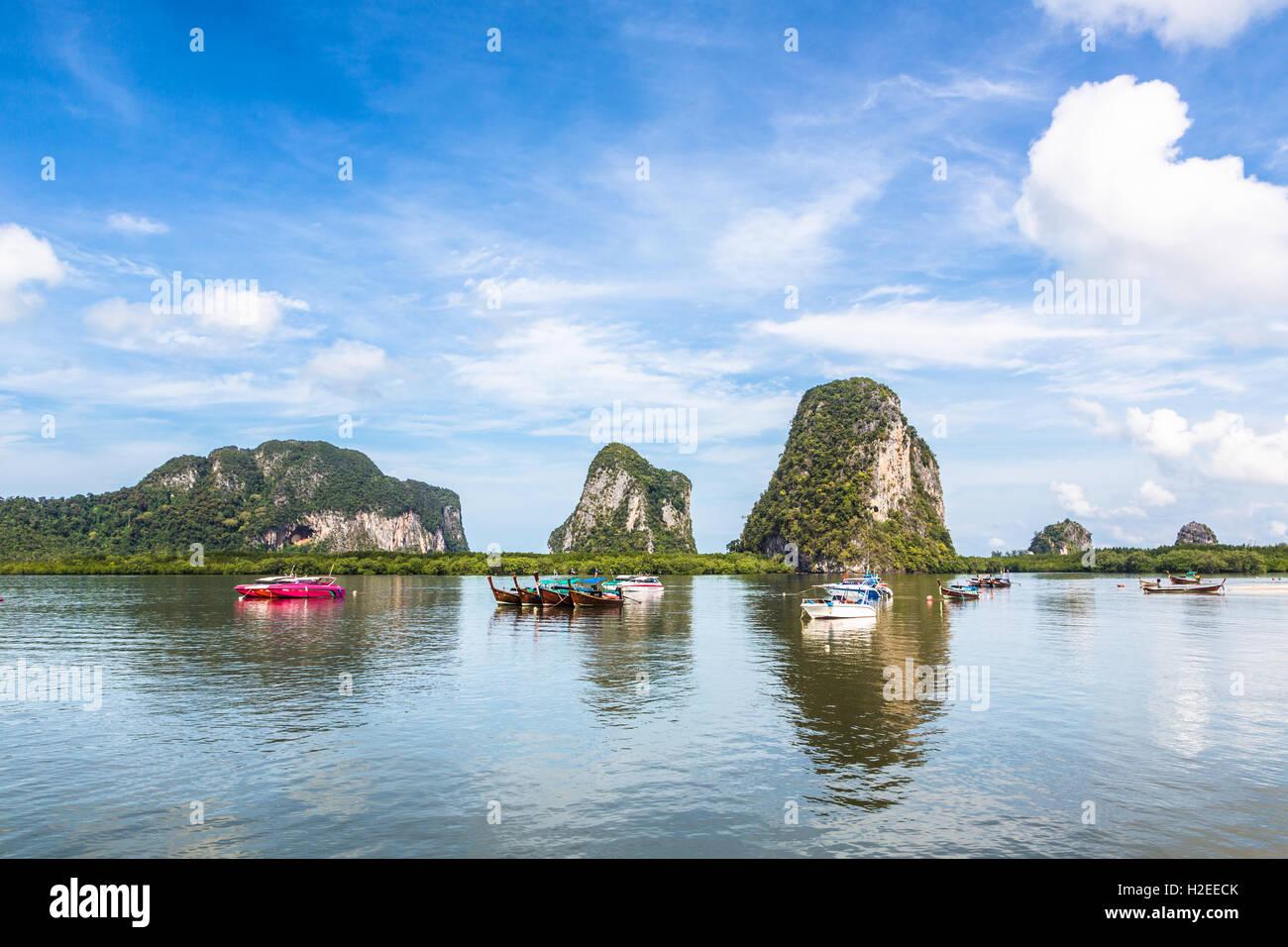 Boats mooring in a bay in front of karst formation in the Trang islands in south Thailand Stock Photo