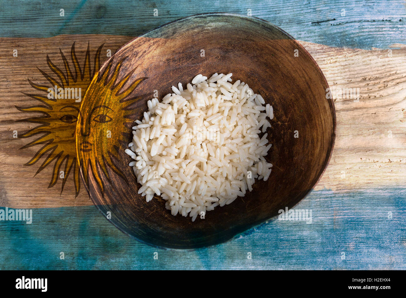Poverty concept, bowl of rice with Argentine flag on wooden background Stock Photo