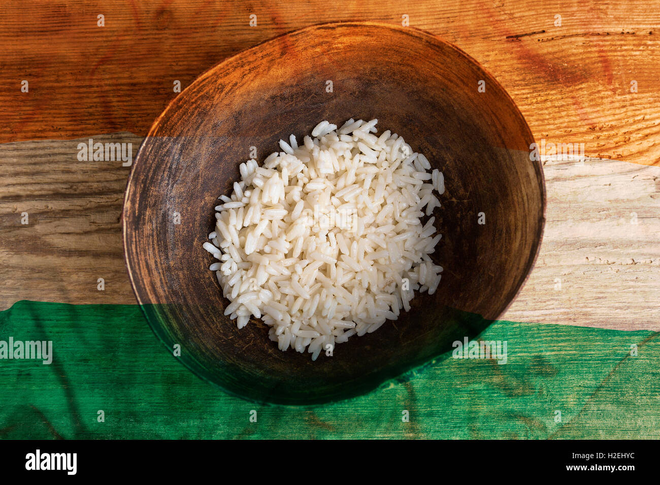 Poverty concept, bowl of rice with Indian flag on wooden background Stock Photo