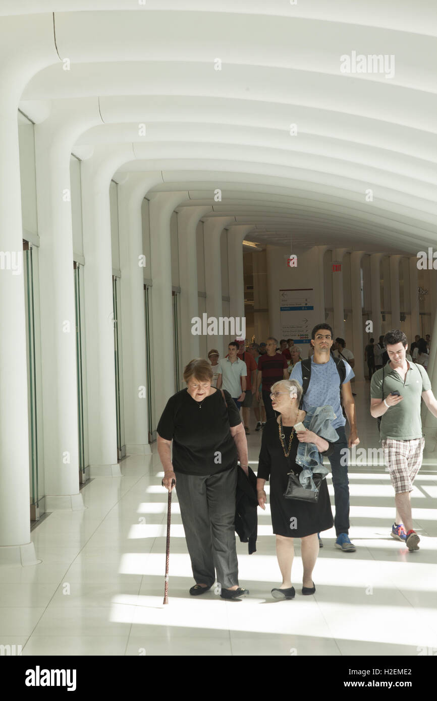 Visitors and shoppers in the Oculus Mall at the World Trade Center walk through one of the corridors overlooking the central hall on one side and shops on the other. New York City. Stock Photo