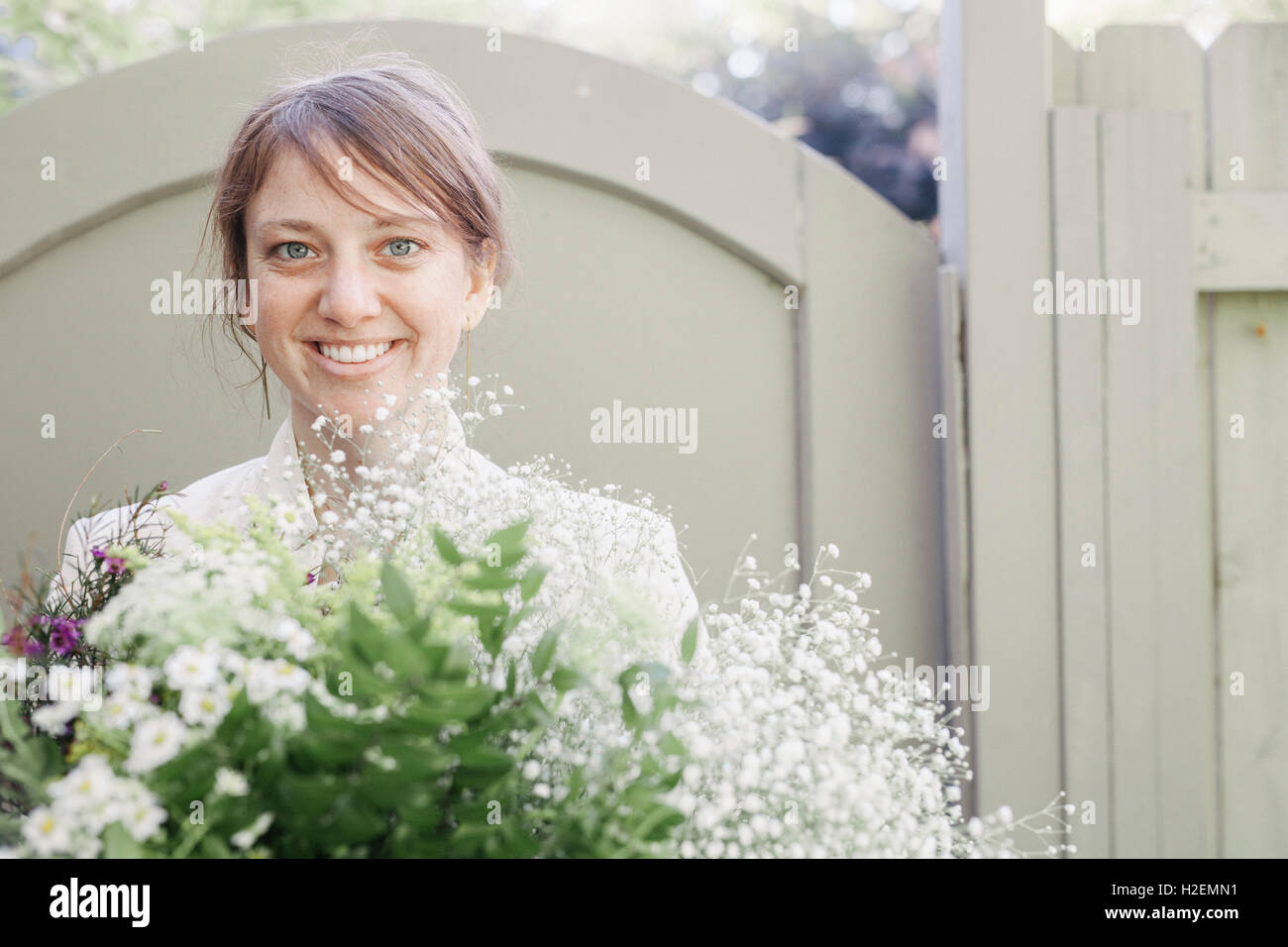 Portrait of a smiling woman carrying a bunch of white flowers Stock ...