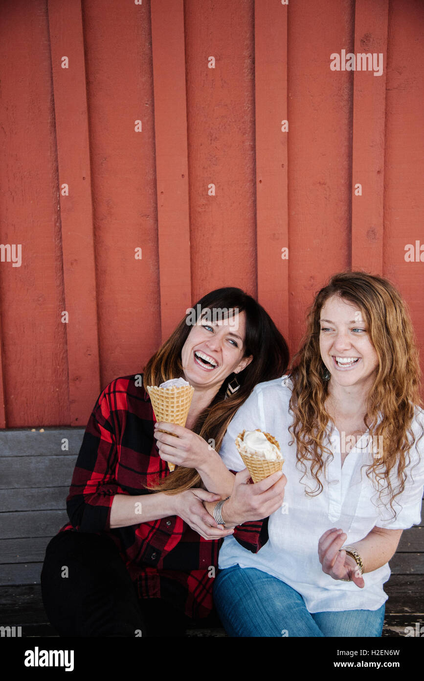 Two Women Sitting On A Bench Eating Ice Cream Stock Photo Alamy