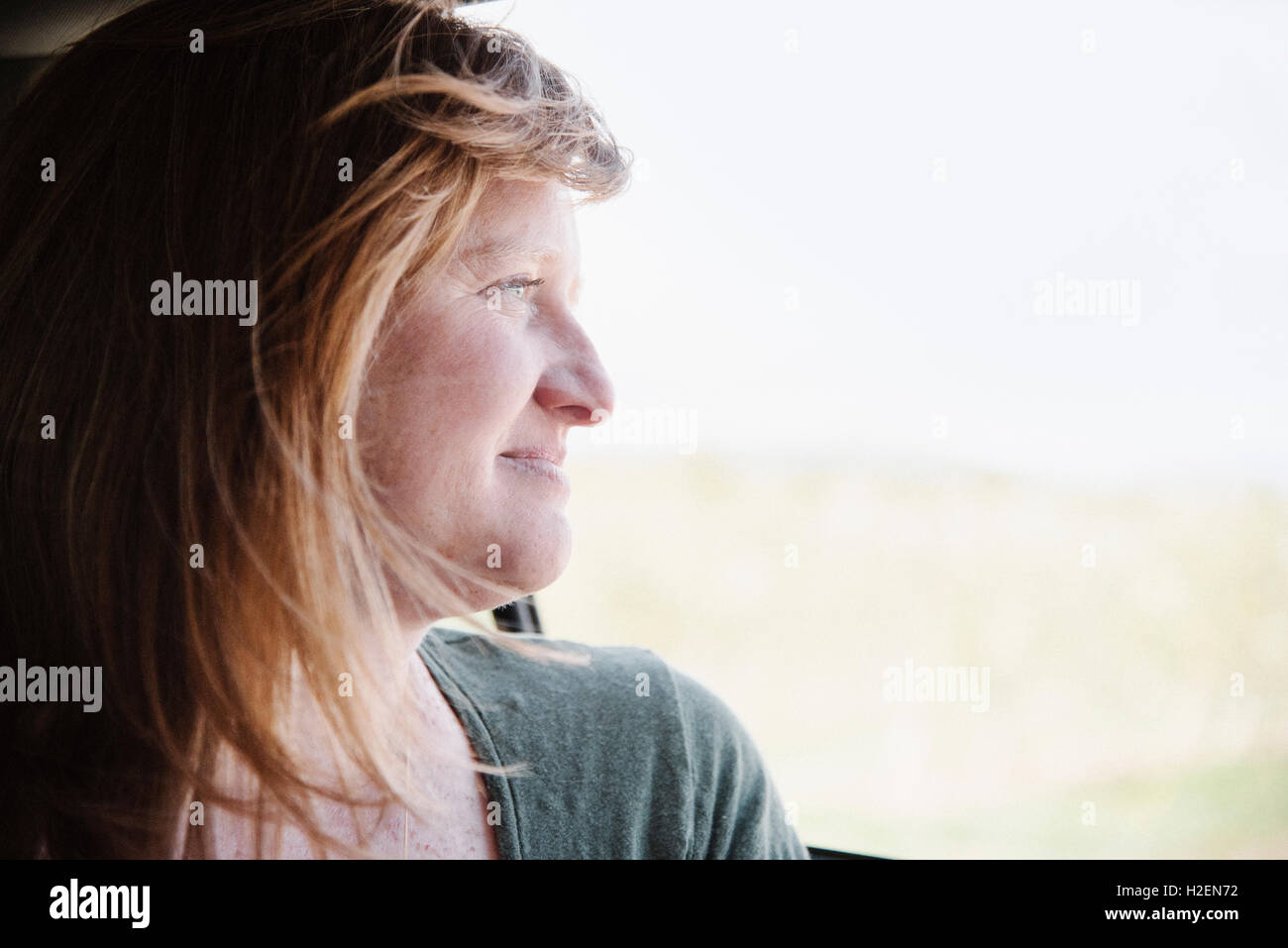 Woman in a car on a road trip, looking out of the window Stock Photo ...