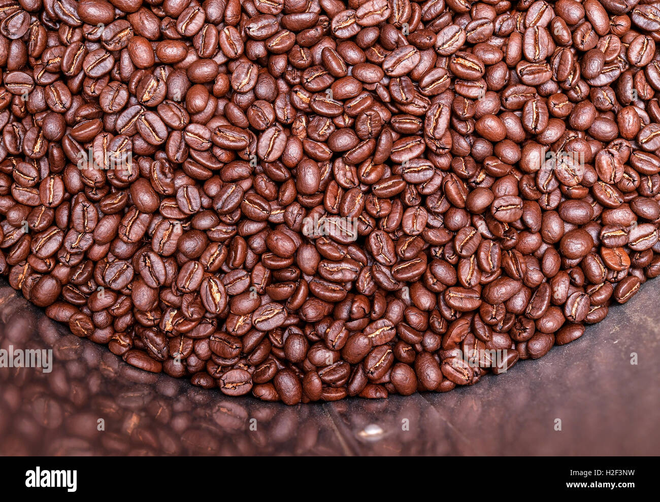 Freshly roasted coffee beans lying in a coffee roasting machine of the