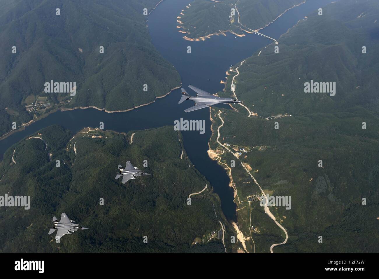 U.S. Air Force B1-B stealth strategic bomber and escort F-15 fighter aircraft fly close to the border between the Republic of Korea and North Korea September 21, 2016 in South Korea. Stock Photo
