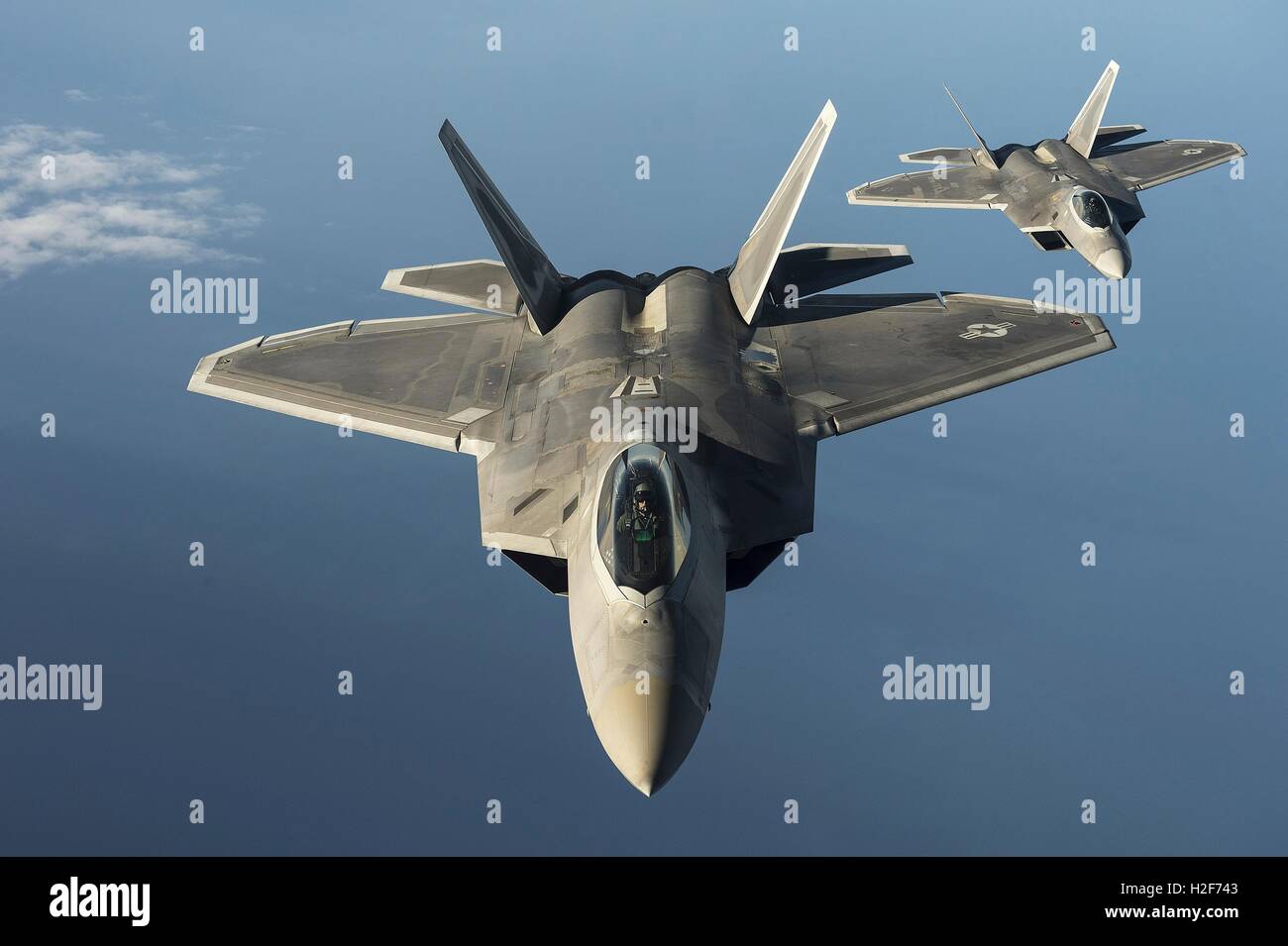 Two U.S. Air Force F-22 Raptor stealth fighter aircraft fly in formation during a training exercise September 4, 2015 over the Baltic Sea. Stock Photo
