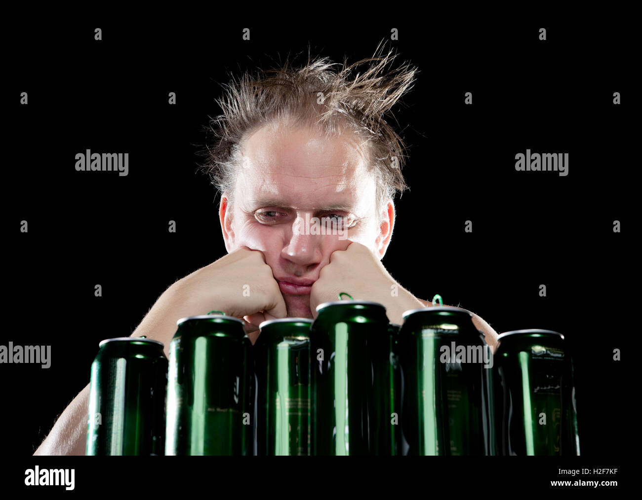 Hangover.The drunk man and is a lot of empty beer cans Stock Photo