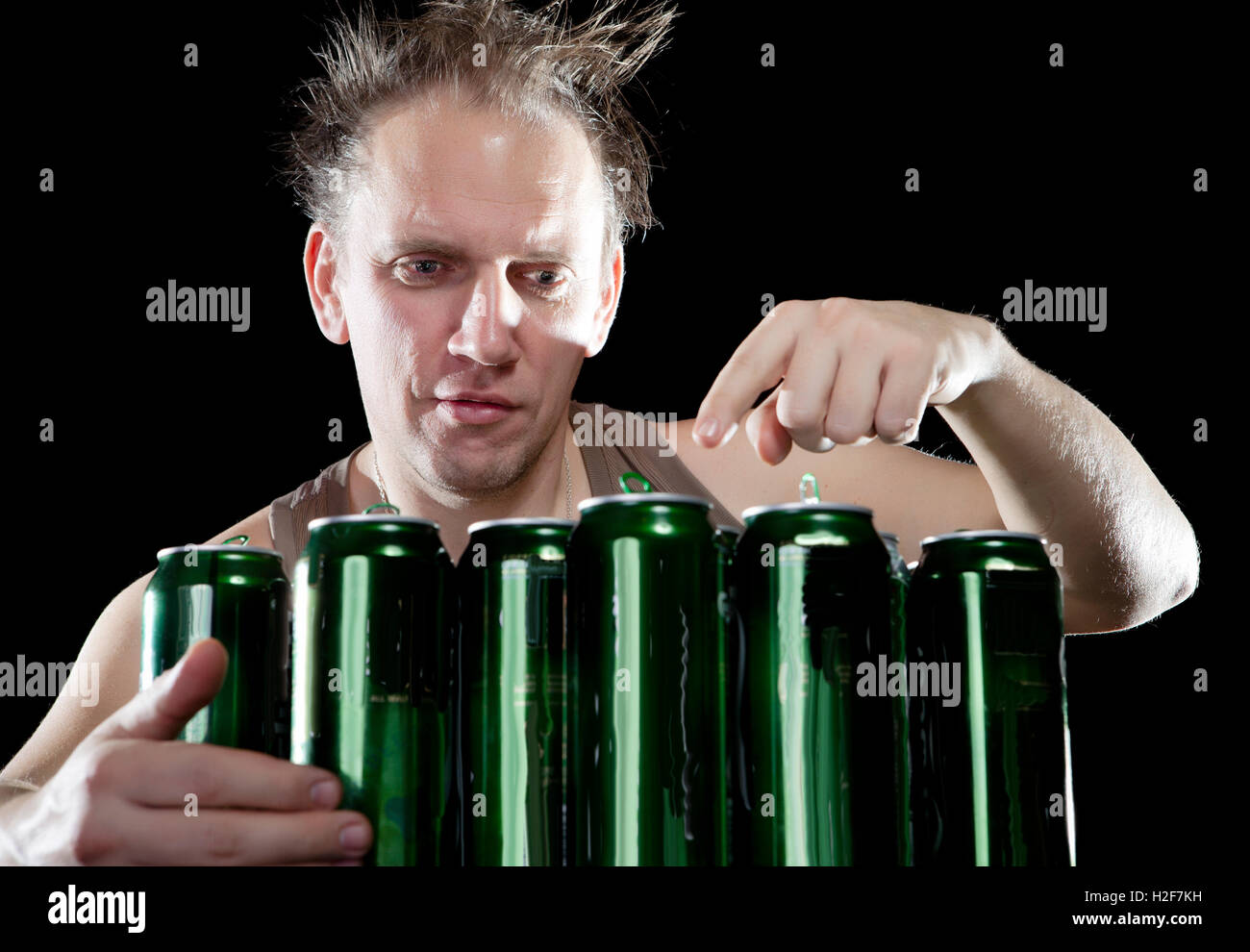 Hangover.The drunk man and is a lot of empty beer cans Stock Photo