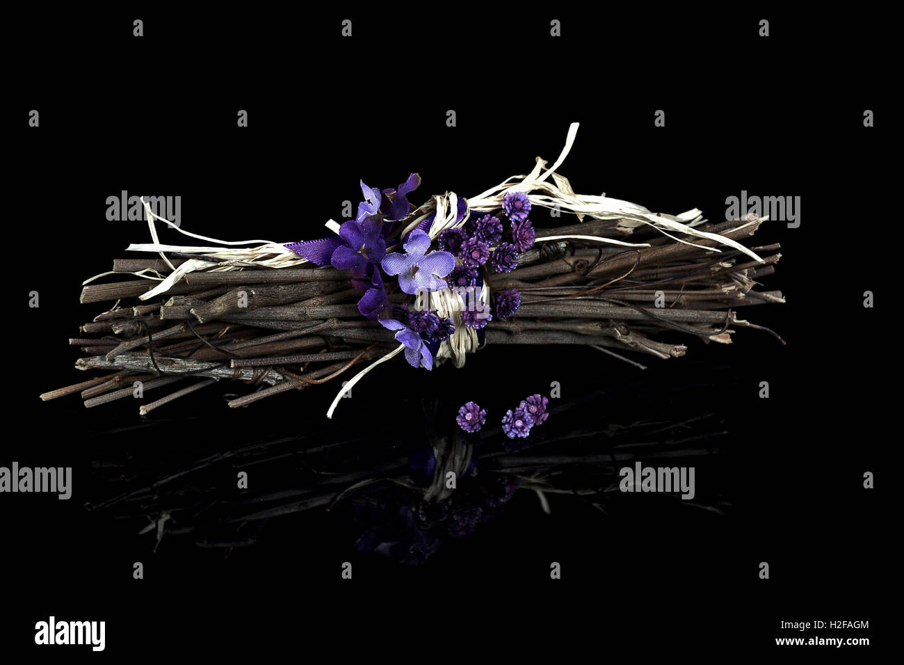 twig bundle with violet bouquet on black reflection Stock Photo